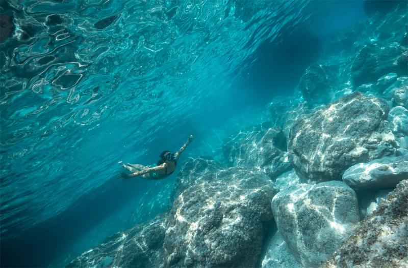 Person swimming in the crystal-clear waters of Playa Esmeralda, Miches, Dominican Republic