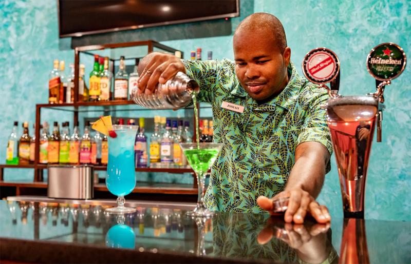 Bartender preparing cocktails behind the bar in Playa Esmeralda, Miches, Dominican Republic.