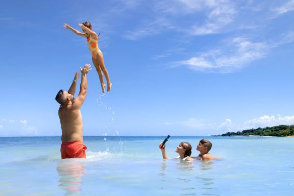 Familia caminando y disfrutando la playa en Dreams Playa Esmeralda Resort & Spa