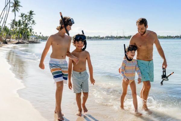 Familia jugando y nadando en el mar frente a Dreams Playa Esmeralda Resort & Spa