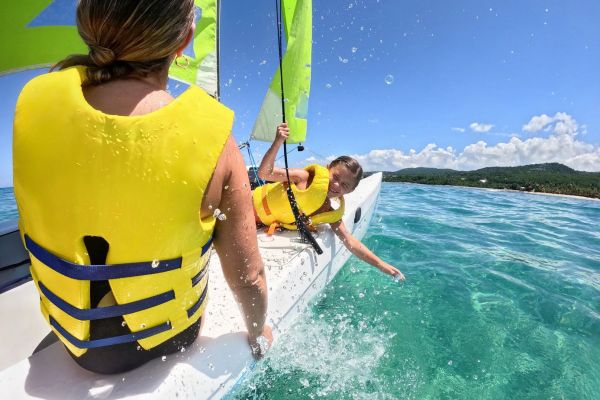 Familia navegando en un Hobie Cat en las aguas de Dreams Playa Esmeralda Resort & Spa