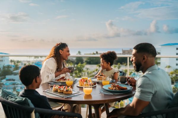 Familia disfrutando un desayuno completo en terraza del Dreams Playa Esmeralda Resort & Spa