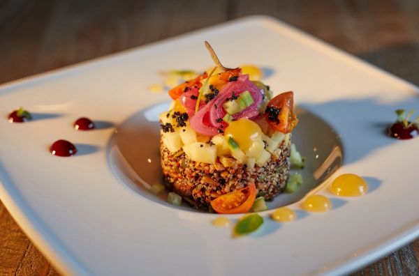 Mesa servida para cena gourmet con vino y presentación elegante en Dreams Playa Esmeralda Resort & Spa
