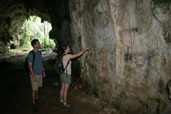 Turistas observando formaciones rocosas en cueva de Los Haitises