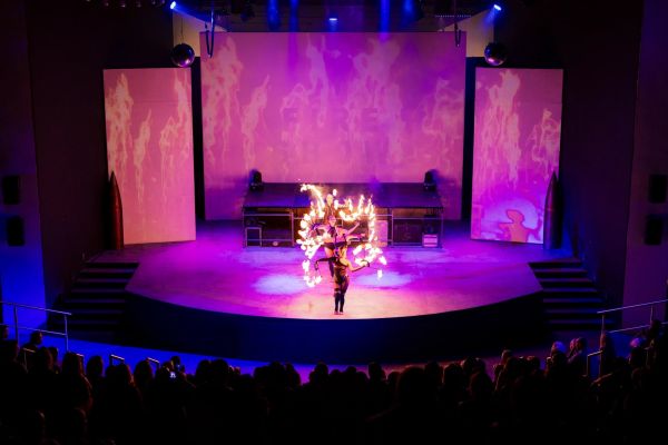 Artista realizando show de fuego en un escenario nocturno de Secrets Playa Esmeralda Resort & Spa