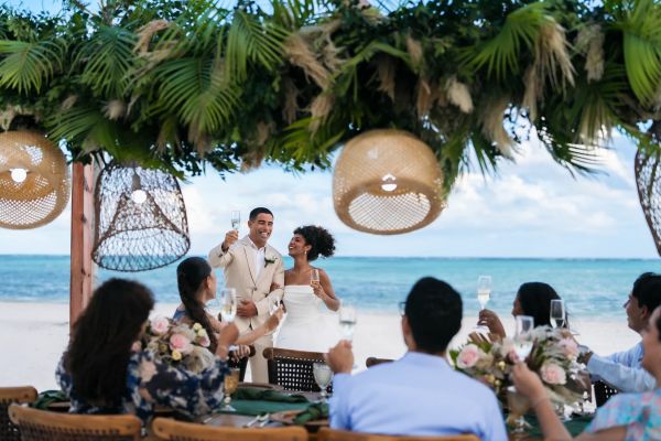 Novios brindando con sus invitados en una celebración en Secrets Playa Esmeralda Resort & Spa